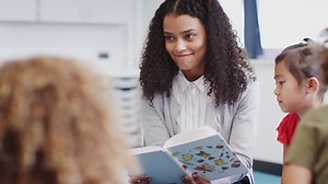 clip-1024860755-female-infant-school-teacher-reading-book-children