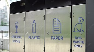 Separate waste containers for general waste, plastic, paper and dog waste in urban environment. Stock Video