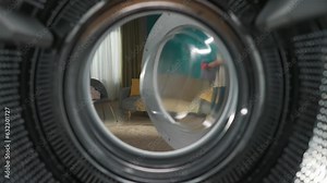 View from inside the empty washing machine young man walks into the room with laundry basket