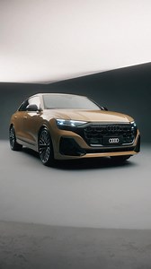 Se você acredita que todo detalhe importa, esse carro é para você. Conheça o novo Audi Q8. Um Audi nos máximos detalhes. #AudiQ8 #MaximosDetalhes #30AnosAudiBR #quattro #PraTodosVerem Um Audi Q8 dourado aparece em um estúdio de fundo preto com luz branca. A câmera foca nos bancos, com o texto: “Bancos super esportivos em couro Valcona.” Em seguida, a câmera destaca as rodas com o texto: “Novas rodas de 23 polegadas Audi Sport.” Depois, a câmera mostra os detalhes do sistema de som Bang & Olufsen