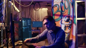 Tracking shot of asian hacker arriving in hidden underground shelter, prepared to launch DDoS attack on websites. Cybercriminal starting work on script that can crash businesses servers