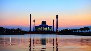 silhouette mosque at sunset reflect on water