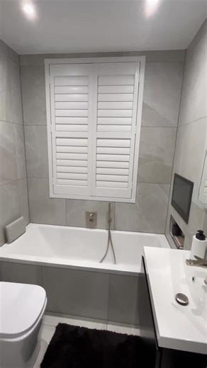 Compact bathroom, big impact. The client sent us this video and it’s the perfect proof that small spaces can still feel dreamy. This compact family bathroom fits a bath, shower, toilet and vanity, plus wall storage, without feeling cramped. And yes... that is a built in bath tv for next level wind down mode. Want your bathroom to feel bigger, calmer, and easier to live with? Link in bio. #bathroomsbydesign #firsttimebuyer #smallbathroom #bathroomrenovation #bathroommakeover