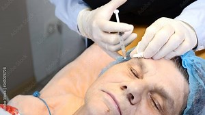 Close-up shot of beautician applying anesthesia injection with syringe to senior female client. woman in her 70s getting ready for beauty treatment in healthcare clinic. 4k footage