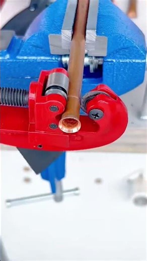 Precision pipe cutting using a handheld rotary tubing cutter securely clamped in a bench vise