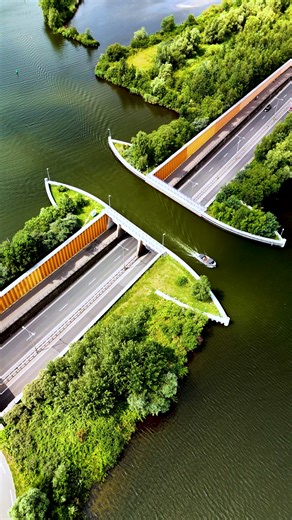 Das Veluwemeer-Aquädukt in Harderwijk ist ein technisches Meisterwerk: Eine 25 Meter lange Wasserstraße führt über die vielbefahrene N302 mit 28.000 Fahrzeugen täglich. So fließt der Verkehr – auf Straße und Wasser – ungehindert weiter. Ein geniales Beispiel niederländischer Ingenieurskunst! 🚗⛵️ 🏘️ TIPPS! Ferienparks & Campingplätze am Veluwemeer: ✅ Europarcs Veluwemeer: siehe https://tinyurl.com/bde5srpz ✅ Molecaten Park Flevostrand: siehe https://tinyurl.com/4bvvw5u8 ✅ Landal Waterpark Veluw