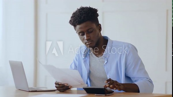 Coronacrisis financial report. Young african man calculating costs and income at home office