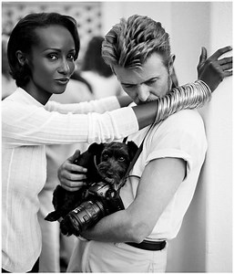 This iconic photograph of Iman and David Bowie, taken by Bruce Weber in 1995, was captured in South Africa for Vogue Italia. The image reflects the elegance and chemistry of the couple, combining fashion and art with Weber's signature aesthetic. The photo is part of a series of portraits that celebrate the love and partnership between Bowie and Iman, highlighting their sophistication and cultural impact. | Gerard Sanchezz