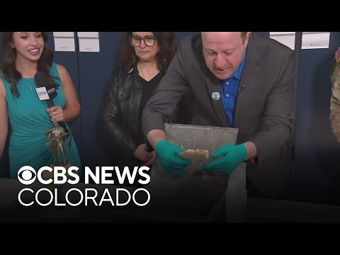 Gov. Jared Polis opens box from 1907 found underneath statue at Colorado State Capitol