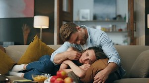 Loving husband consoling wife in upset mood indoors. Caring man giving support understanding empathy to stressed woman in tears sympathizing. Depressed crying lady laying pillow desperate of problem