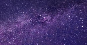 Seamless loop galaxy exploration through outer space to glowing purple galaxy of the milky way.