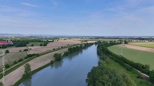 Great Adige River. Water flowing through fields and countryside. Aerial shot of the long watercourse that crosses the Veneto. Natural park near Verona.