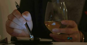 Woman having wine and using cell phone