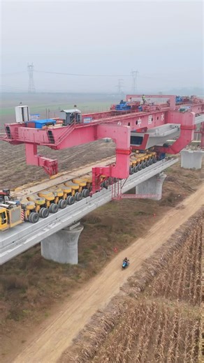 Technology Hype | A large bridge construction operation using a heavy launching gantry and multi-axle transporter system. The massive red gantry crane is... | Instagram