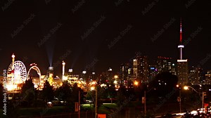 Time-lapse of the carnival at the Canadian National Exhibition. Lights on the roller coasters and Ferris wheel, and the CN tower and Toronto skyline. Stock Video
