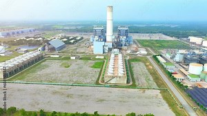 A Thermal Power Plant utilizes non-renewable resources to produce electricity, emitting greenhouse gases and contributing to climate change. Bird's eye view by drone.