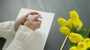 clip-3445456559-hands-woman-writing-crumpling-paper-table-decorated