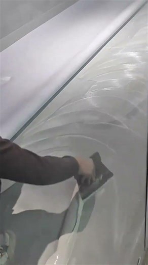 spreading white adhesive on floor with spatula tools to install new carpets in office building area