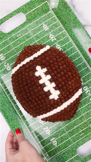 Football shaped cake - easy peasy! 🏈🏈🏈🏈 I used a 9” cake and cut a 1.75” strip out of the center. Then put the 2 halves back together! Piping tip: @wiltoncakes 32 Chocolate Buttercream Recipe: • 2 sticks (1 cup) unsalted butter, room temp • 350g confectioners sugar • 65g hershey’s cocoa powder (sifted) • 2 TBSP milk • 1 TBSP light corn syrup (*optional- it adds a bit of shine) • 1 TSP vanilla extract • pinch of salt 🏈🏈🏈🏈🏈 1. Mix butter on its own for 2 mins in electric mixer with paddle