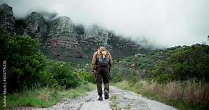 Mature man, hiker and walking with stick on mountain for fitness, adventure or outdoor journey in nature. Back view of male person trekking with backpack, bag and cloudy sky in natural environment Stock Video