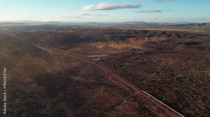 Open iron mine in Australian desert at sunrise. Aerial forward
