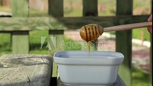 Dripping Honey by Dipper on Plate. Drained Liquid Honey