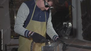 Blacksmith cuts iron details via plasma cutter at his workshop, slow motion.