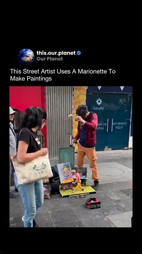 Our Planet on Instagram: "This street artist creates paintings by controlling a marionette instead of holding the brush directly. The puppet’s hands are connected to strings that guide the paint across the canvas, turning the act of painting into a live performance. The artist carefully adjusts the strings to control pressure, direction, and movement, blending puppetry with visual art. Via: @galeria_morionet #art #streetart #creativity #performanceart #design"