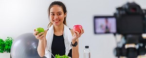 Beautiful asian woman healthy blogger is showing apple fruit and clean diet food in front of the camera to recording vlog video live streaming at homefitness influencer on social media online | Premium Photo
