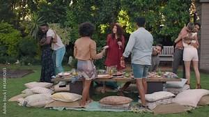 happy friends arriving at garden party celebration hugging enjoying friendship reunion gathering sitting at table with healthy food sharing weekend picnic together 4k