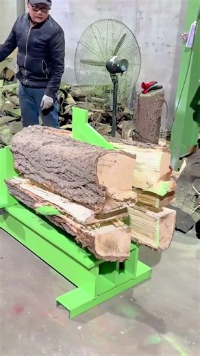 splitting a large tree trunk into several pieces of wood using a green electric hydraulic machine