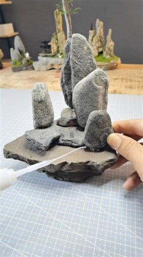 Arts Promote 🎨 on Instagram: "Golden Stone Landscape Art is a Chinese miniature artist who constructs detailed landscapes using stones, moss-like greenery, and natural textures. He carefully positions each rock to form mountains and terrain, then adds adhesive and fine green materials that mimic grass and vegetation, gradually bringing each scene to life. Artist: mj15006597 / 金石造景 on Douyin #art #artist #miniature"