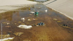 Humanity polluting environment and river waters with household liter and plastic. Climate change footage 4K, California USA. Disgusting view on human garbage trashed in the water of Los Angeles river