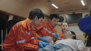 Team of men and women of emergency medical help rescue a seizure patient in an ambulance with heart pumps and ventilators. EMS Paramedics React Quick.