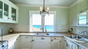 The kitchen showcases a stunning ocean view through large windows, blending natural light with elegant design elements