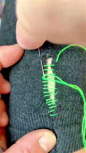 stitching fabric tear using needle and thread in a neat repeated pattern to close the opening clean