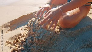 Attractive young woman building a horrible sandcastle on the beach