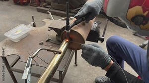 Welding stainless steel pipes with a tig welder.Pipe welding using a special machine.Weld stainless steel pipe and add stainless steel wire to the workpiece.Car pipe welding.