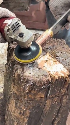 Smoothing the surface of a wooden handle using a power grinder to achieve a refined and profesional