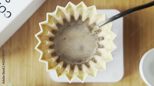 Making coffee. Speciality coffee at home. Barista pours water from the drip kettle into the coffee dripper. Aromatic filter coffee on the table. Ceramic funnel, glass server and filter paper. Top view Stock Video