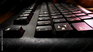 A young child typing in a keyboard of computer. Practicing typing slowly searching for letters. Learn typing