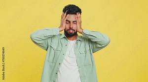 Irritated angry Indian man screams from stress tension problems feels horror hopelessness fear surprise shock expresses rage nervous, quarrel. Arabian young guy isolated on yellow studio background