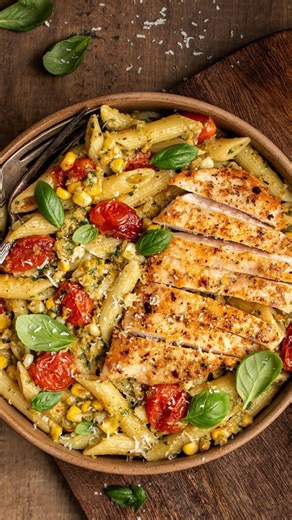 Corn pesto pasta with parmesan crusted chicken and bursting tomatoes