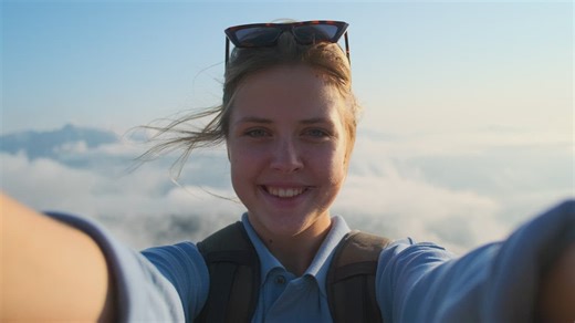 Happy girl on top of mountain making peace sign to the camera - Free Stock Video