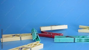 High frame rate slow motion falling objects video. Blue screen background video. Super slow motion video with falling clothes line pegs. Stock Video