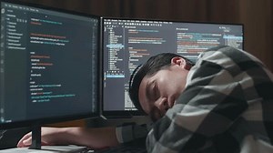 Close Up Of Asian Male Programmer Sleeping While Creating Innovative Software Engineer Developing App, Program, Video Game On Desktop Computer At Home. Terminal With Coding Language