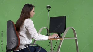 Frustrated office worker trying to use desktop computer with critical error message on blue screen display. Green screen background.