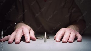 Close-up shot that slowly dollies in on a prisoner's hands, cuffed to a table in an interrogation room. Stock Video