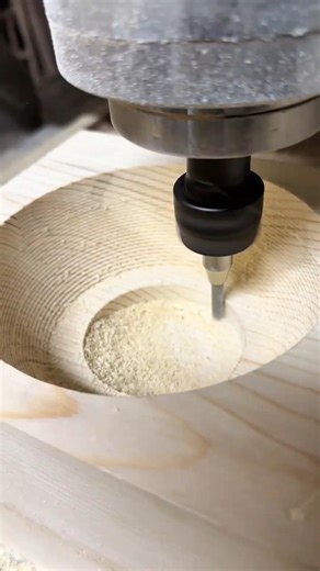 Hollowing out a circular bowl in a wooden block using an industrial CNC milling machine