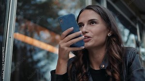 girl using smart phone voice recognition, dictates thoughts, voice dialing message at night evening home student model young in cafe audio ai speech